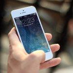 Pessoa segura um smartphone e navega pela tela.