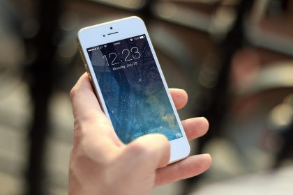 Pessoa segura um smartphone e navega pela tela.